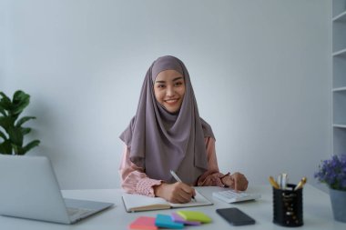 Finansal, Planlama, Pazarlama ve Muhasebe, iş yerindeki belge ve hesap makineleriyle mali durumları kontrol eden Müslüman kadın çalışanın portresi.