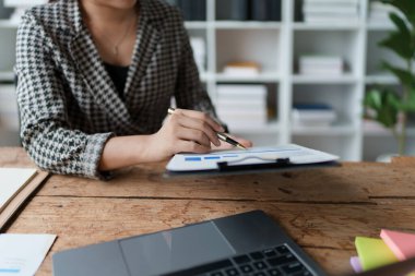 Finansal, Planlama, Pazarlama ve Muhasebe, Asyalı çalışanın portresi Mali durumları kontrol eden Belgeler ve hesap makineleri kullanarak..