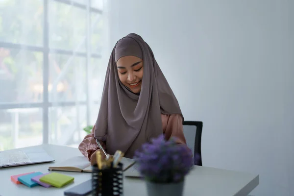마케팅 업무중인 문서와 계산기를 사용하여 문서를 확인하는 이슬람 여성의 초상화 — 스톡 사진