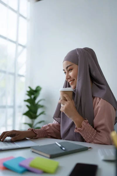 노트북 컴퓨터와 커피를 마시는 이슬람 여성의 — 스톡 사진
