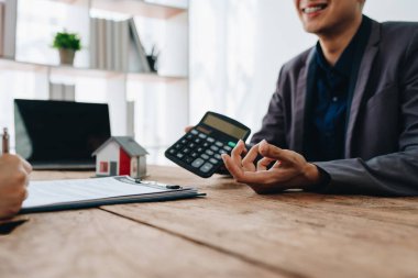 Teminat, mortgage, sözleşme, sözleşme, kontrat, emlakçı ya da banka memuru elinde hesap makinesi olan bir müşteri ile anlaşma imzalamadan önce bir ev satın almak için teklif sunar..