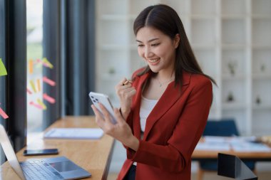 Ofisteyken cep telefonu kullanan heyecanlı iş kadını, iş kavramları