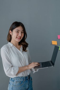 Muhasebe belgelerini tutan Asyalı genç iş kadını yönetici, avukat ya da şirket çalışanı finansal verileri ya da dizüstü bilgisayarla çalışan pazarlama raporlarını kontrol ediyorlar. Belge yönetimi.