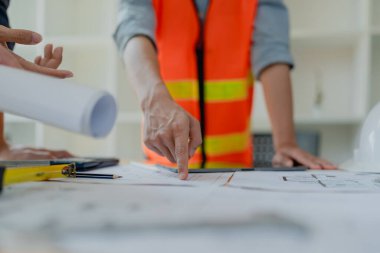 Evler ve binalar için mimari ve mühendislik tasarımı hakkında kağıt işleri ve zemin planı çizimlerinin maliyet tahmini için çok ırklı mühendis beyin fırtınası ve ölçümü.