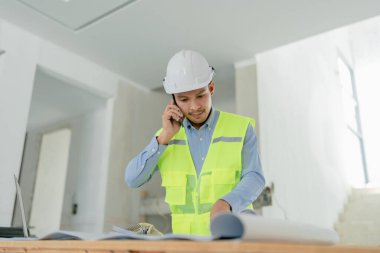 Çok ırklı mühendis, bina ve evler için mimari ve mühendislik tasarımı hakkında planlar ve kat planı çizimlerinin maliyet tahmini için beyin fırtınası ve ölçümlemesi.