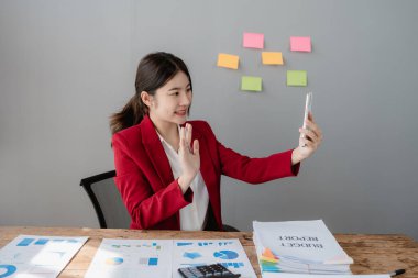 Gülümseyen ve akıllı telefon kullanan güzel bir iş kadınının portresi..