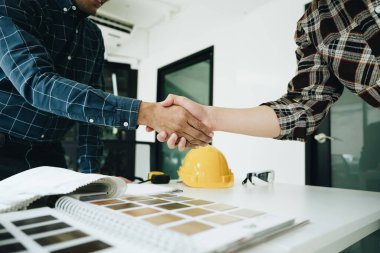 Mühendisler, tasarımcılar ve iç mimarlar, müşterilere sunulacak malzeme ve renkleri seçerek iç mekan tasarımını sonuçlandıran el sıkışma kulübesi anlaşmalarıdır.