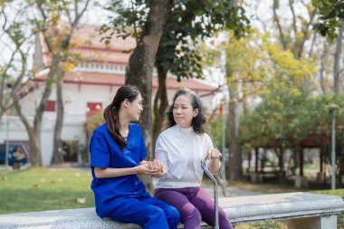 Hasta bakımı, kadın bakımı, genç Asyalı kadınlar yaşlılara bakıyorlar, koltuk değneği veriyorlar ve hastalara yürüyorlar, ve parklarda bacaklarını ve dizlerini çalıştırıyorlar.