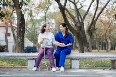 Hasta bakımı, kadın bakımı, genç Asyalı kadınlar yaşlılara bakıyorlar, koltuk değneği veriyorlar ve hastalara yürüyorlar, ve parklarda bacaklarını ve dizlerini çalıştırıyorlar.