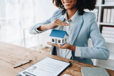 Emlakçı Afrikalı Amerikalı, Ajan, arazi alıp satma, emlak vergisi, eve zarar verme riskini garanti altına almak için evi koruma kavramını gösteriyor. sigorta kavramları.