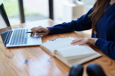 Mutlu Latin kız kolej öğrencisi uzaktan öğrenim kursu, uzak üniversite web sitesi ya da laptop üzerinden konuşma videosu alıyor ve evdeki ya da kampüsteki sanal toplantı seminerinde not defteri kullanıyor.