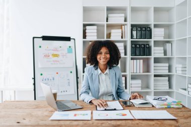 Amerikalı Afrikalı iş kadını doküman, bilgisayar dizüstü bilgisayar, hesap makinesi, evrak işleri, kazanan ve gülümseyen başarı elde etmek için mutlu. finans ve yatırım kavramları.