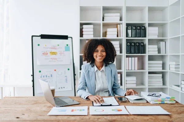 Amerikalı Afrikalı iş kadını doküman, bilgisayar dizüstü bilgisayar, hesap makinesi, evrak işleri, kazanan ve gülümseyen başarı elde etmek için mutlu. finans ve yatırım kavramları.