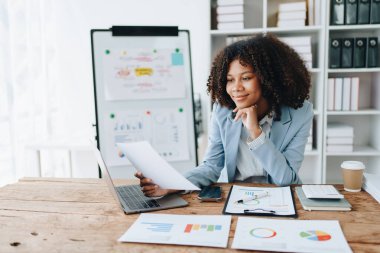 Finansal, Planlama, Pazarlama ve Muhasebe, Afro-Amerikan işçilerin portresi. Mali tabloları kontrol ederken iş yerindeki belge ve hesap makinelerini kullanıyorlar..