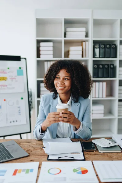 Amerikalı Afrikalı iş kadını doküman, bilgisayar dizüstü bilgisayar, hesap makinesi, evrak işleri, kazanan ve gülümseyen başarı elde etmek için mutlu. finans ve yatırım kavramları.