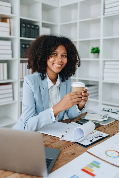 Amerikalı Afrikalı iş kadını doküman, bilgisayar dizüstü bilgisayar, hesap makinesi, evrak işleri, kazanan ve gülümseyen başarı elde etmek için mutlu. finans ve yatırım kavramları.