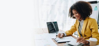 Genç Asyalı kadınlar, vergi makbuzlarını internetten ödemeden önce ev sayımında mali evraklarla çalışıyorlar. Ekonomi tasarrufu, denetim kavramları ve tasarruf şansı bulmaktan memnun olacak bir bütçe planlıyorlar.