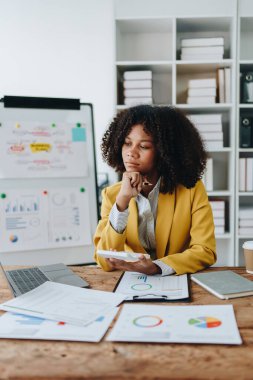 Genç Asyalı kadınlar, vergi makbuzlarını internetten ödemeden önce ev sayımında mali evraklarla çalışıyorlar. Ekonomi tasarrufu, denetim kavramları ve tasarruf şansı bulmaktan memnun olacak bir bütçe planlıyorlar.