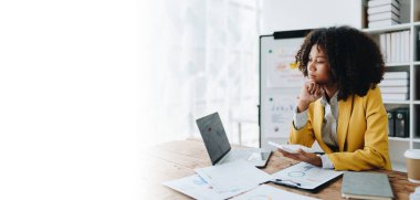 Genç Asyalı kadınlar, vergi makbuzlarını internetten ödemeden önce ev sayımında mali evraklarla çalışıyorlar. Ekonomi tasarrufu, denetim kavramları ve tasarruf şansı bulmaktan memnun olacak bir bütçe planlıyorlar.