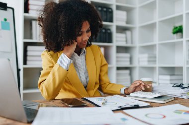 Genç Asyalı kadınlar, vergi makbuzlarını internetten ödemeden önce ev sayımında mali evraklarla çalışıyorlar. Ekonomi tasarrufu, denetim kavramları ve tasarruf şansı bulmaktan memnun olacak bir bütçe planlıyorlar.