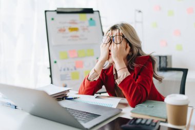 İşletme sahibi, bilgisayar ve finansal tabloları kullanan kadın portresi piyasayı genişletmek için endişe verici bir ifade..
