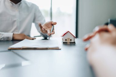 Garanti, mortgage, anlaşma, sözleşme, imza, emlakçı müşterilere önemli belgeleri imzalamadan önce anlaşmayı okumaları için gerekli belgeleri gösteriyor..