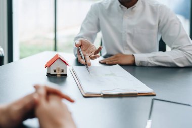 Garanti, mortgage, anlaşma, sözleşme, imza, emlakçı müşterilere önemli belgeleri imzalamadan önce anlaşmayı okumaları için gerekli belgeleri gösteriyor..