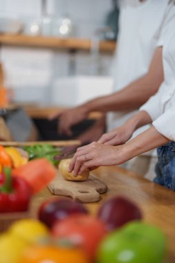 Yemek yapmak ya da evde salata yapmak için patates kesen çiftler.