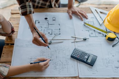 Çok ırklı mühendis, bina ve evler için mimari ve mühendislik tasarımı hakkında planlar ve kat planı çizimlerinin maliyet tahmini için beyin fırtınası ve ölçümlemesi.