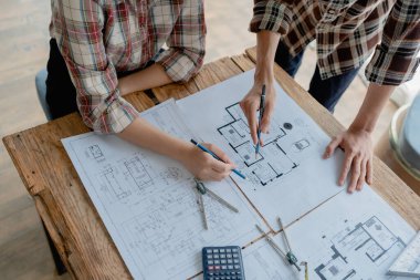 Çok ırklı mühendis, bina ve evler için mimari ve mühendislik tasarımı hakkında planlar ve kat planı çizimlerinin maliyet tahmini için beyin fırtınası ve ölçümlemesi.