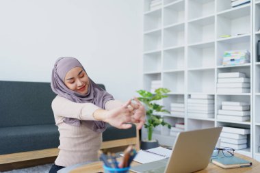 Müslüman lisans öğrencileri bilgisayar sistemiyle online e-öğrenme aldıktan sonra kaslarını gevşetiyorlar