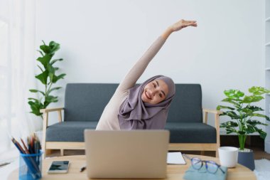 Müslüman lisans öğrencileri bilgisayar sistemiyle online e-öğrenme aldıktan sonra kaslarını gevşetiyorlar