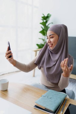 Müslüman üniversite öğrencisi arkadaşlarıyla iletişim kurmak için cep telefonu kullanıyor