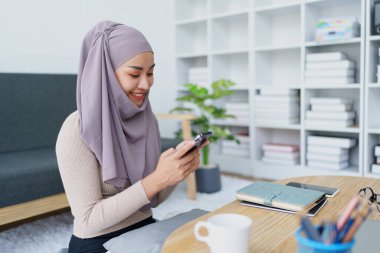 Müslüman üniversite öğrencisi arkadaşlarıyla iletişim kurmak için cep telefonu kullanıyor