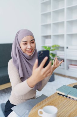 Müslüman üniversite öğrencisi arkadaşlarıyla iletişim kurmak için cep telefonu kullanıyor