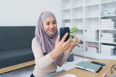 Müslüman üniversite öğrencisi arkadaşlarıyla iletişim kurmak için cep telefonu kullanıyor