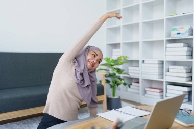 Müslüman lisans öğrencileri bilgisayar sistemiyle online e-öğrenme aldıktan sonra kaslarını gevşetiyorlar