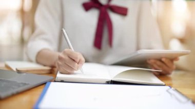 Tabletteki verilerden kalem kaydeden genç, sevimli Asyalı kadın. Yüksek kalite 4k görüntü