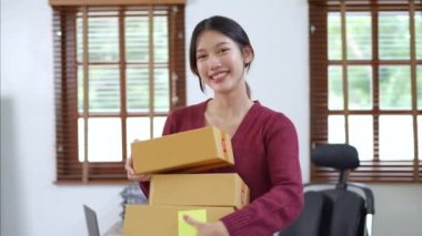 Bağımsız Asyalı kadın çevrimiçi satıcı girişimi başlatarak müşterilere ve KOBİ teslimat konseptine göndermek üzere ürünleri paketlemeye başladı. Yüksek kalite 4k görüntü