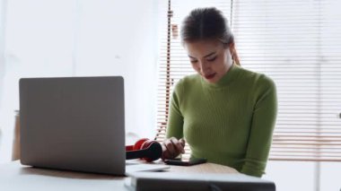 Evde çalışan Asyalı genç bir kadın dinlenirken, sosyal medya izlerken, haberleri okurken, evde online alışveriş yaparken. Yüksek kalite 4k görüntü