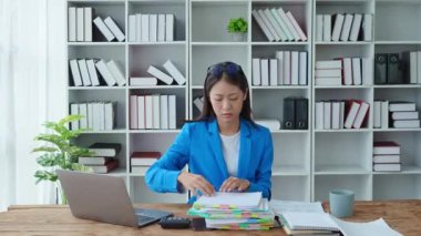 Yanma sendromu, kağıt işleri stresi, Asyalı beyaz ofis çalışanı masadaki stres ve hüsranı gösteren belgeleri arıyor. Yüksek kalite 4k görüntü