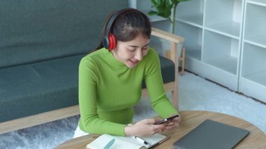 Rahat Asyalı kadın kulaklık takıyor akıllı telefon kullanarak sosyal medyada geziniyor, haberleri kontrol ediyor, müzik dinliyor ya da koltukta oturan mesajları dinliyor. Milenyum bayanı evde vakit geçiriyor. Yüksek kalite