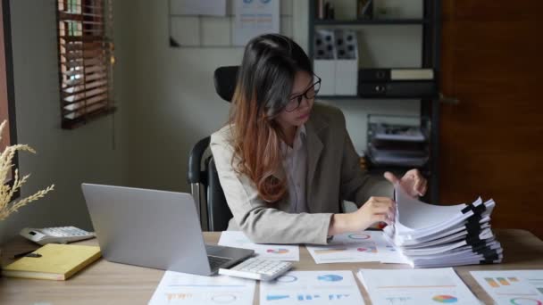 若いアジアの実業家やブックキーパーは 書類事務 木製のテーブルの上のコンピュータを使用して予算に取り組んで強調顔を示しています 高品質4K映像 — ストック動画