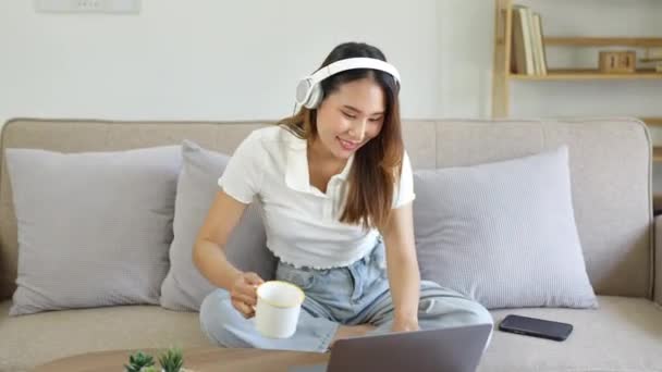 Hermosa Mujer Asiática Usando Computadora Con Auriculares Escuchando Música Sosteniendo — Vídeos de Stock
