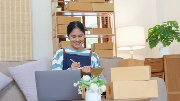 小さなスタートアップ 中小企業の所有者 アジアの女性起業家の肖像は 顧客とインナーボックスに製品を梱包する前に製品を手配するために注文を確認します フリーランスの概念 — ストック動画