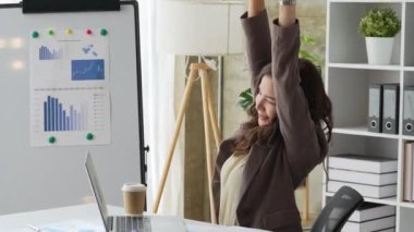 Genç Asyalı iş kadını ofisteki dizüstü bilgisayarında daktilo kullanmadan önce geriniyor. İş teknolojileri konsepti. Yüksek kalite 4k görüntü