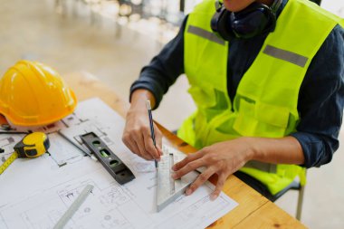 Mühendisler planlı çizim ve ofis tasarım projesini tartışıyorlar.