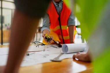 Mühendisler planlı çizim ve ofis tasarım projesini tartışıyorlar.