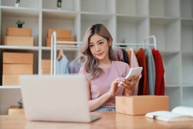 Küçük işletme, çevrimiçi işletme sahibi, genç kadın kar hesap makinesi kullanıyor ve envanteri kontrol ediyor.