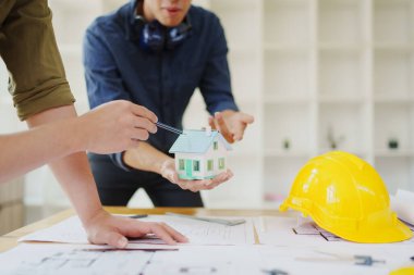 Çok ırklı mühendis, bina ve evler için mimari ve mühendislik tasarımı hakkında planlar ve kat planı çizimlerinin maliyet tahmini için beyin fırtınası ve ölçümlemesi.
